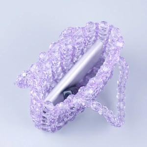 Vue détaillée du sac à main perlé violet montrant la capacité avec un smartphone