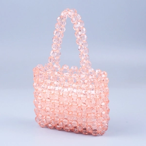 Détail d'un sac à main artisanal en perles acryliques facettées avec double poignées