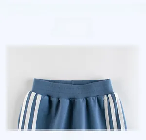 Detail show of elastic ribbed waistband and triple white stripes on blue sports pants