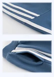 Detail view of boys blue joggers with white side stripes and smooth pocket stitching