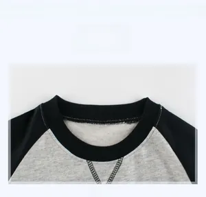 Detail show of children's raglan hoodie featuring ribbed crew neck and grey black contrast
