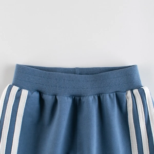Close-up of boys' light blue athletic sweatpants with triple white stripes and elastic waist