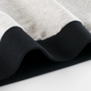 Close-up of grey marl knit fabric and black ribbed cuff detail on children sweatshirt