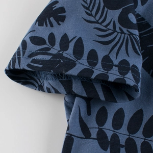Detail of double-stitched sleeve cuff on navy blue cotton T-shirt with palm leaf print