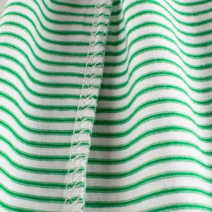 Close-up of green and white striped cotton kids T-shirt showing fine stitching detail