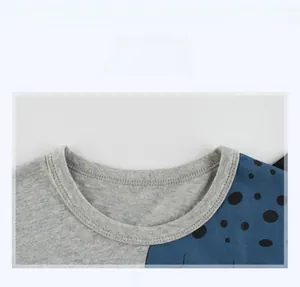 Close-up of ribbed crew neck and polka dot knit fabric on boy's cotton t-shirt
