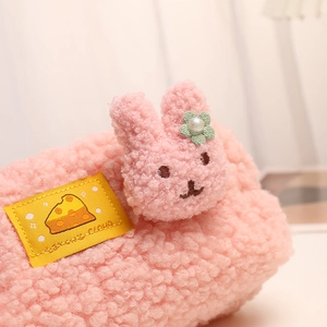 Close-up of pink sherpa fleece pencil case with cute rabbit detail and yellow woven label