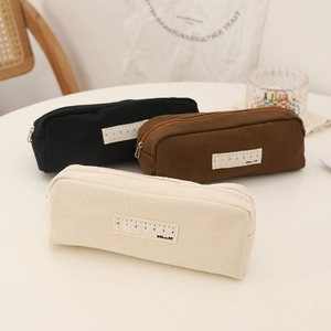Detailed texture of canvas pencil case showing the ruler patch and sturdy metal zipper