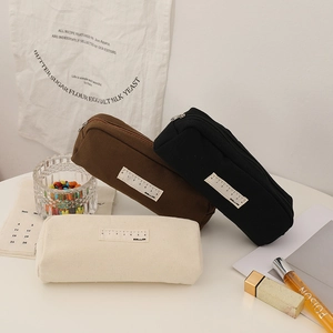 Detailed view of canvas pencil cases in black, white, and brown with ruler patches