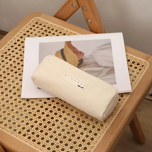Minimalist canvas pencil case in cream white with ruler design on a woven chair