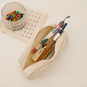 Detail view of cream canvas pencil case showing large capacity and woven texture fabric