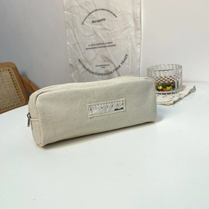 Detail of off-white canvas pencil case featuring a ruler label and large capacity storage