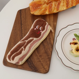 Macro detail of plush bacon shaped pencil case featuring cute embroidery and zipper closure