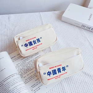 Close-up of canvas pencil pouches featuring screen-printed minimalist lettering and pockets