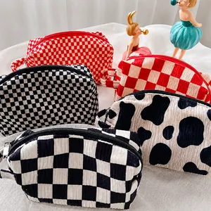 Detailed view of velvet checkered and cow print cosmetic bags with sturdy metal zippers