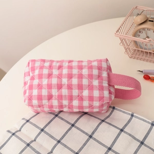 Detail der rosa-weißen gesteppten Kosmetiktasche aus Stoff mit praktischem Seitengriff