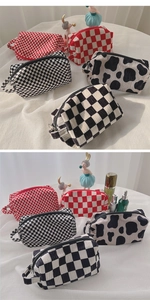 Detail of plush velvet checkered and cow print makeup bags with sturdy metal zippers