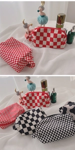 Detail of seersucker makeup bags in red checkerboard, black check and cow print patterns