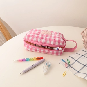 Nahaufnahme der rosa karierten gesteppten Kosmetiktasche mit Teddybär-Patch