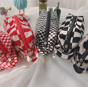 Detail of red and black checkered velvet makeup bags showing textured bubble fabric