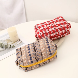 Detail of red checkered tweed and blue wave knit cosmetic bags with zippers