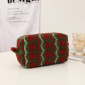 Detail of red and green festive knit cosmetic bag with wave pattern and side handle