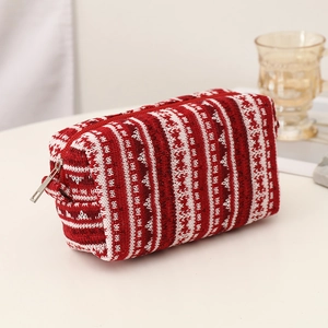 Close-up of red and white knit pattern texture on festive storage bag with zipper