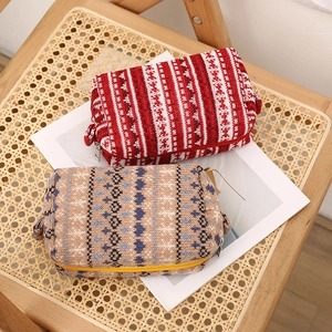 Close-up of knitted cosmetic bags featuring Nordic jacquard patterns and metal zippers