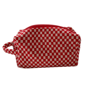 Portable red and white checkered velvet makeup bag with side handle and zipper closure