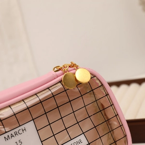 Close-up of pink checkered pencil case with transparent PVC window and gold double zippers