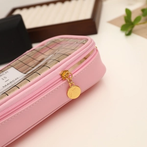 Detailed close-up of pink pencil case featuring a transparent window and golden zipper