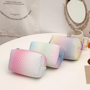 Close-up of gradient PU leather toiletry bags with zigzag stitching on a white table