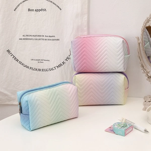 Close-up of three gradient PU leather cosmetic bags with chevron quilting and metal zippers