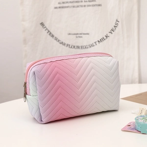 Detail of wave quilted gradient PU leather makeup bag with a pink zipper and metal puller