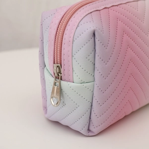 Detail of gradient PU leather makeup bag with V-shaped quilting and heart zipper puller