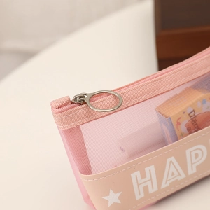 Detailed close-up of pink mesh pencil case with metal zipper and HAPPY leather trim