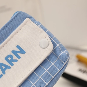 Detail of light blue checkered canvas pencil case with button and fabric texture