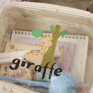 Close-up of a clear PVC makeup bag with giraffe print showing stationery storage inside