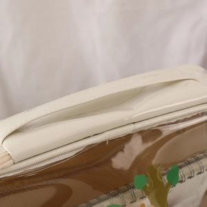 Detail showing the cream white faux leather handle and smooth zipper of the makeup bag