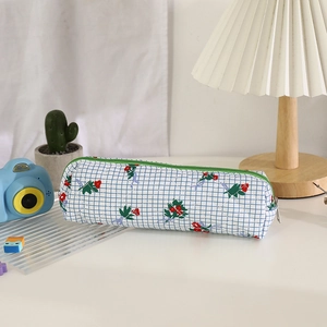 Detailed view of floral canvas pencil case with green zipper on a minimalist desk setup