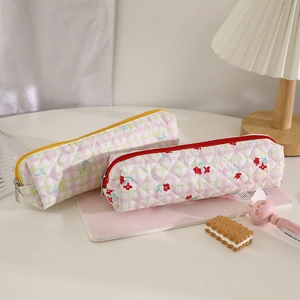 Close-up of quilted floral bear pencil cases in pink and white plaid with zipper details