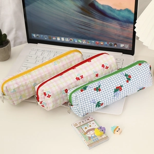 Floral bear pencil cases with grid pattern and zipper for students on laptop keyboard