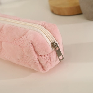 Close-up of pink plush pencil case showing soft quilted texture and metal zipper