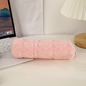 Detailed view of pink plush pencil case with heart quilted texture and metal zipper