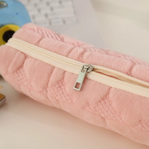 Close-up of pink quilted plush pencil case with zipper and silver rectangular puller