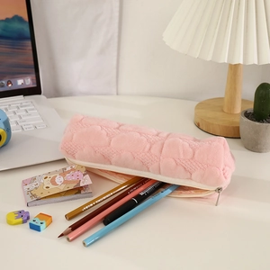 Close-up of pink plush pencil case with heart-shaped quilting and smooth zipper detail
