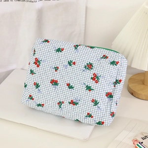 Detailed macro of a quilted cotton floral makeup bag with blue grid and red flowers