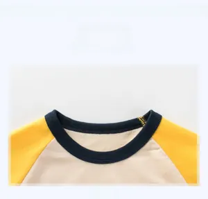 Detail of round neckline with blue ribbed cuff on yellow and white raglan sleeve kids T-shirt