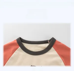 Détail de l'encolure à manches raglan avec bord-côte gris sur un T-shirt en coton