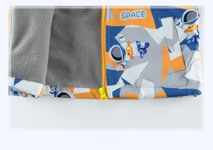 Detail of kids jacket hem with space print, thick polar fleece lining and yellow zipper